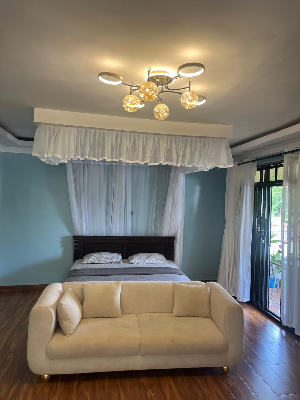 A bedroom with blue walls and a sitting area